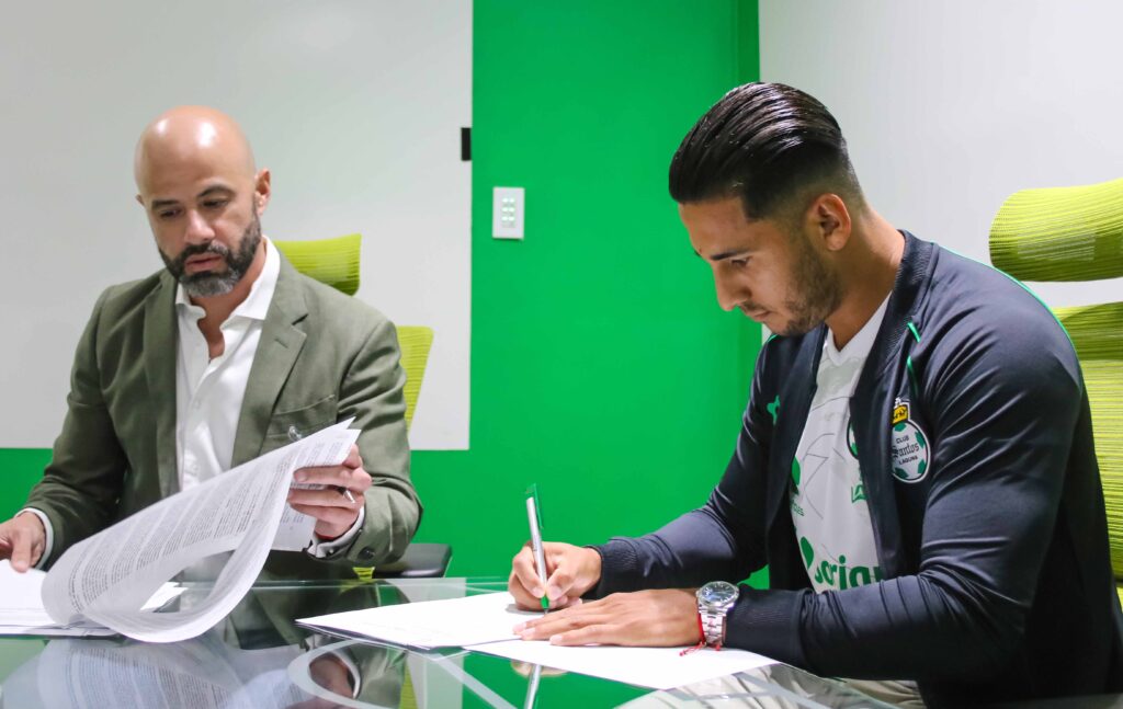 Ex-jogador do Austin FC, Cecilio Domínguez assina contrato ao lado do presidente do Santos Laguna, Dante Elizalde.