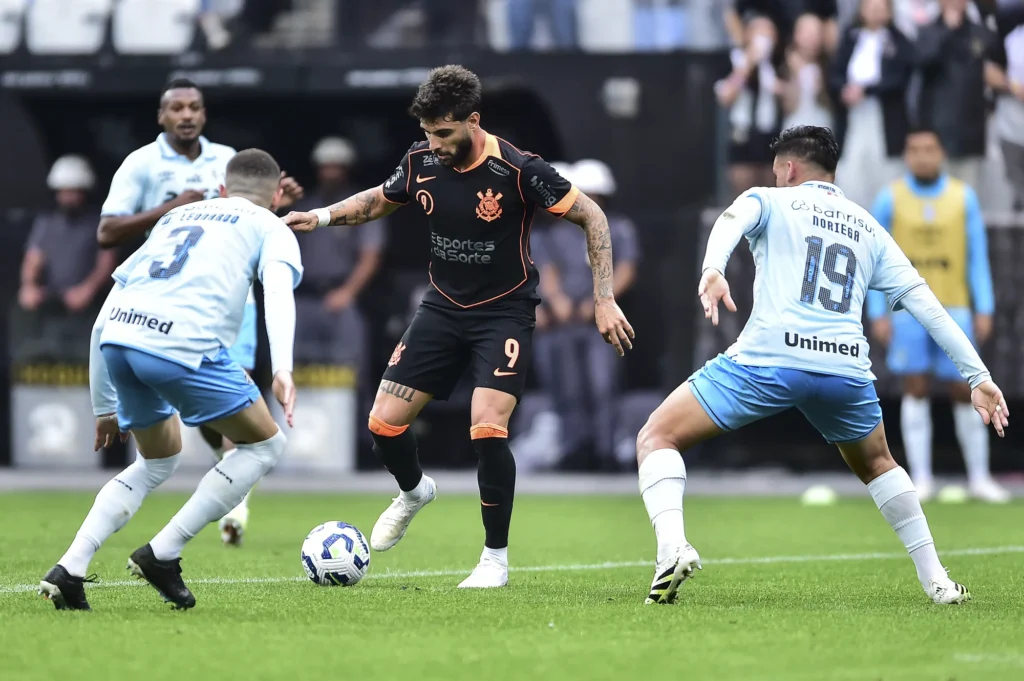 SÃO PAULO, BRASIL - 02 DE NOVEMBRO: Yuri Alberto, do Corinthians, dirige a bola contra Wagner Leonardo e Erick Noriega, do Grêmio, durante uma partida do Brasileirão 2025 entre Corinthians e Grêmio na Neo Quimica Arena em 02 de novembro de 2025 em São Paulo, Brasil. (Foto de Mauro Horita/Getty Images)