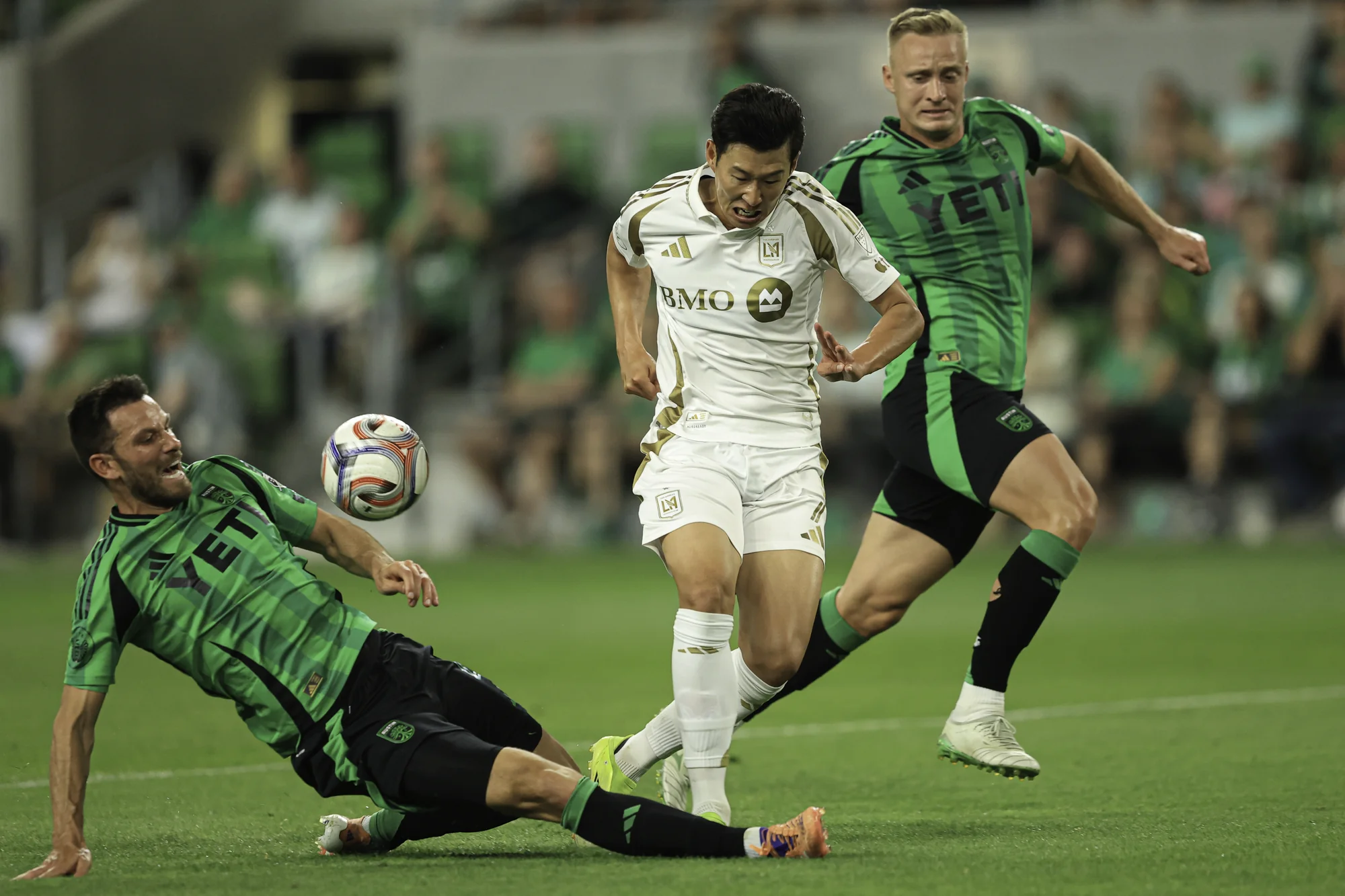 AUSTIN, TEXAS - 21 DE MARÇO: Brendan Hines-Ike #4 do Austin FC e Son HeungMin #7 do Los Angeles FC disputam a posse da bola durante a partida entre o Los Angeles FC e o Austin FC no Q2 Stadium em 21 de março de 2026 em Austin, Texas. (Foto por Daniel Jefferson/Getty Images)